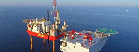 An offshore platform named Seafox 7 stands in the water, surrounded by calm sea and under a blue sky.