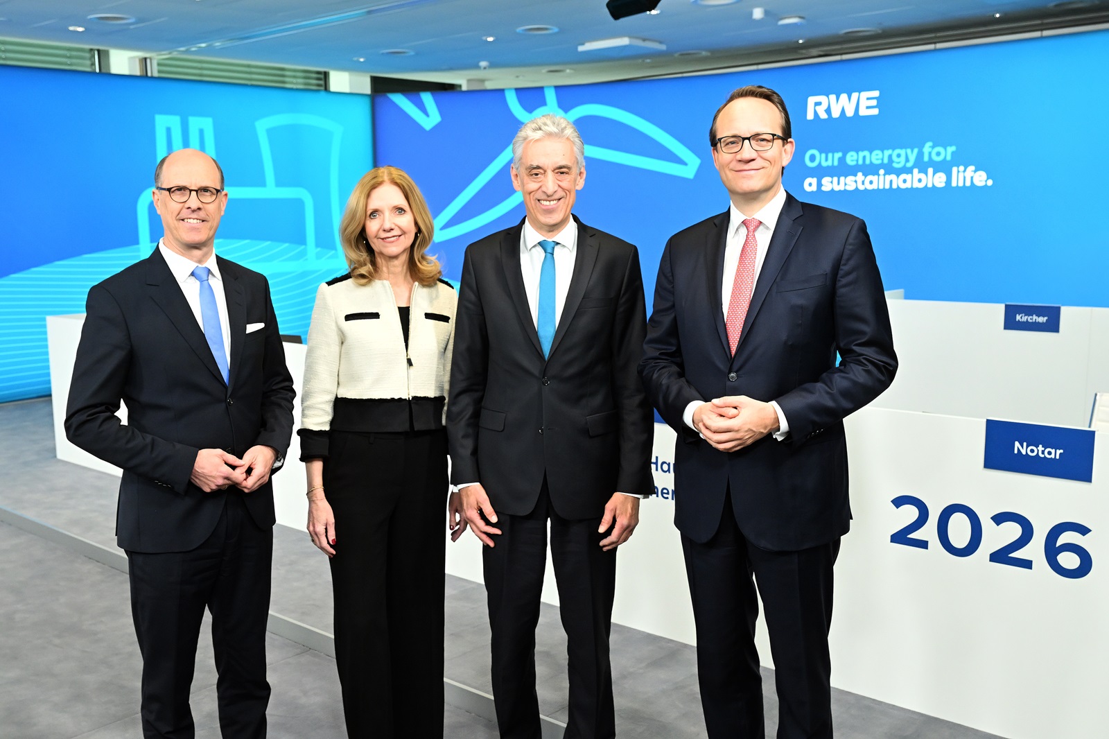 Four members of the executive board and supervisory board are standing in front of the backdrop of the RWE Annual General Meeting.