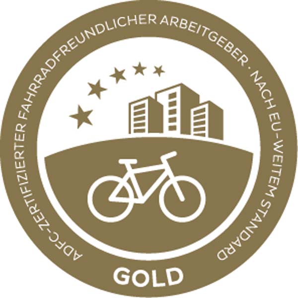 A gold emblem featuring a bicycle, buildings, and stars, signifying a bicycle-friendly employer.